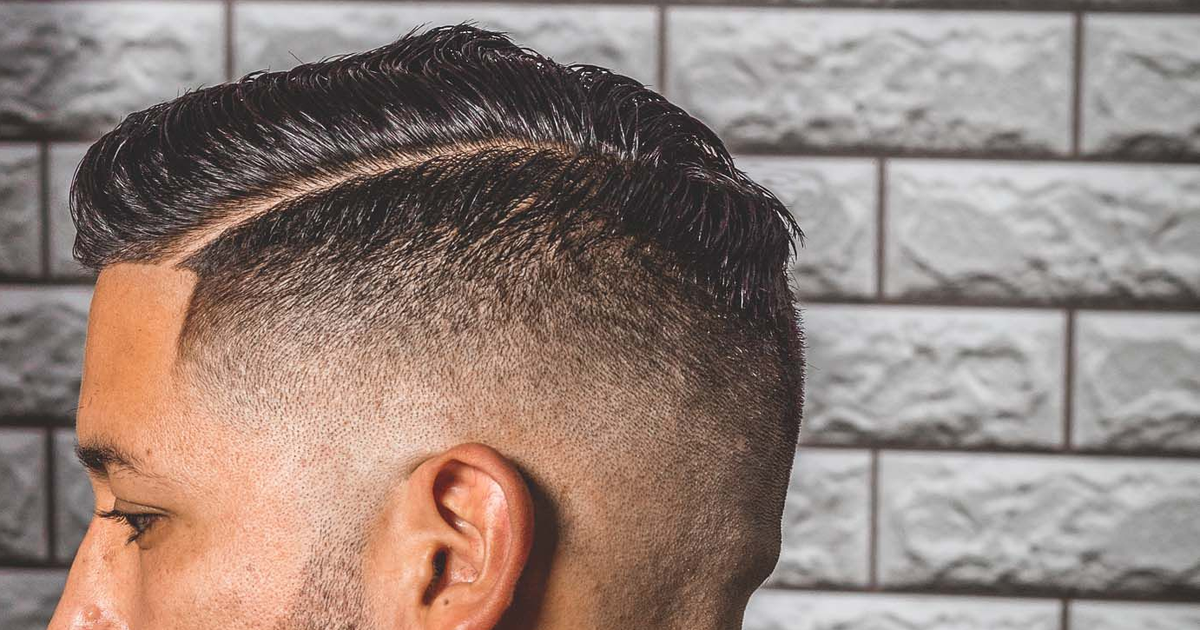 Side profile of a man with a freshly blended short haircut in a salon chair