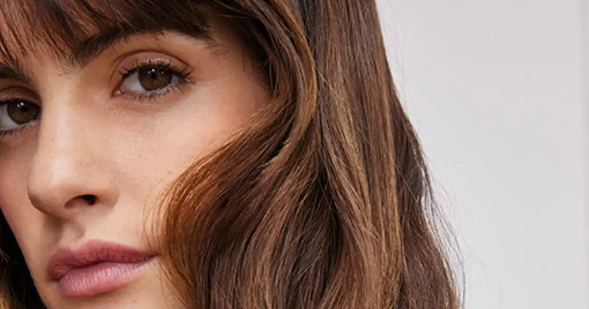 Woman with a soft fringe and flowing layers showing a flattering haircut according to face shape