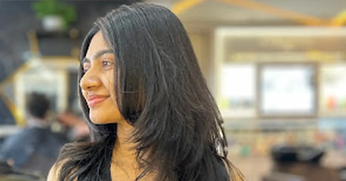 Woman with healthy long dark hair in a salon after a long hair trim that kept her length