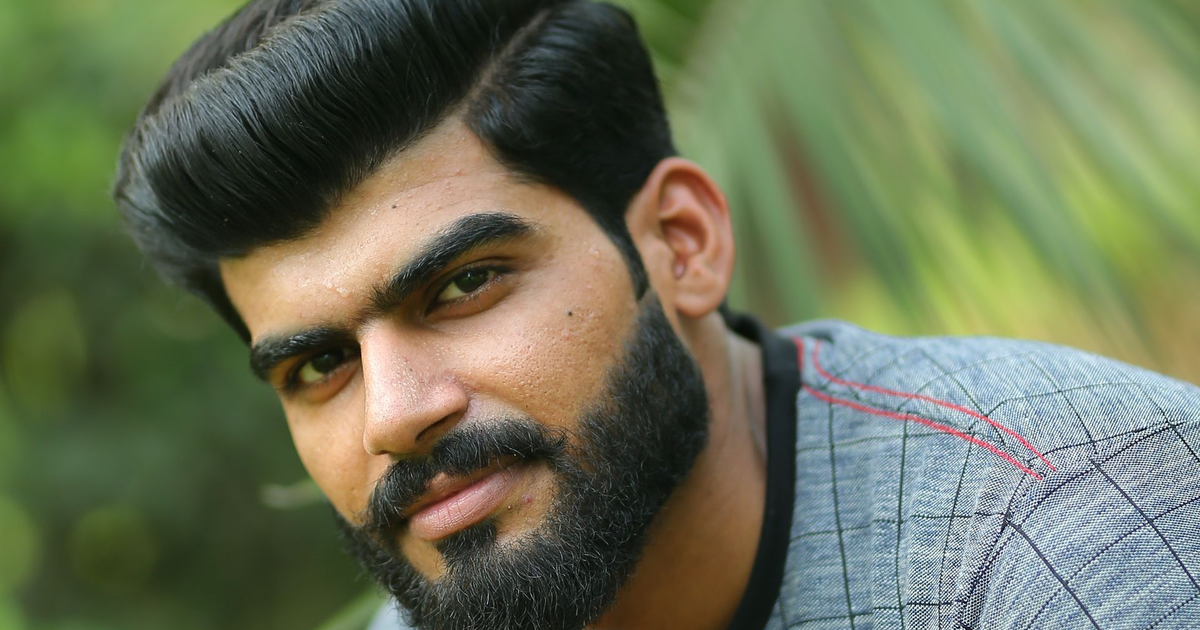 Man with a styled voluminous haircut and full beard showing trending men's haircuts